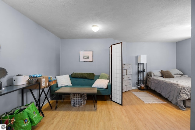 bedroom with hardwood / wood-style flooring and a textured ceiling