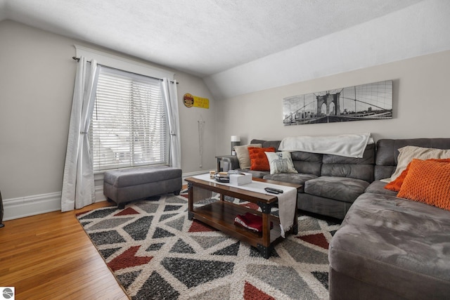 living room featuring a textured ceiling, lofted ceiling, and hardwood / wood-style flooring