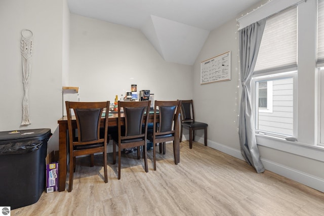 dining space featuring lofted ceiling and light hardwood / wood-style flooring