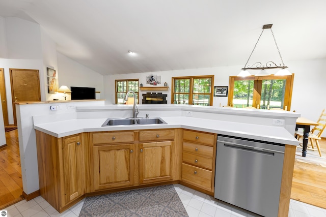 kitchen featuring pendant lighting, sink, light tile patterned floors, dishwasher, and vaulted ceiling