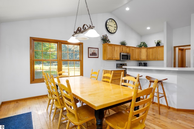 dining area with high vaulted ceiling and light wood-type flooring