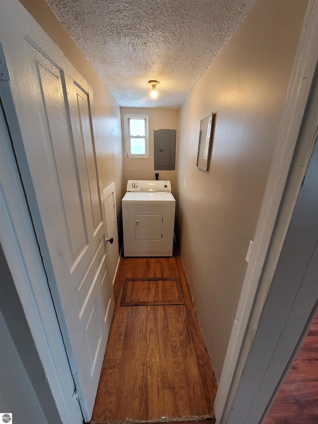 laundry room featuring washer / dryer, a textured ceiling, electric panel, and dark wood-type flooring