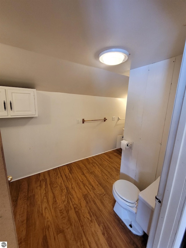 bathroom featuring vaulted ceiling, toilet, and hardwood / wood-style flooring