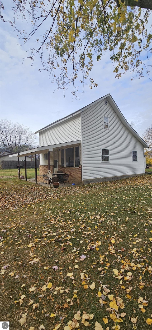 back of property with a patio area and a lawn