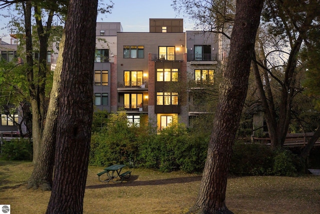 back house at dusk featuring a yard