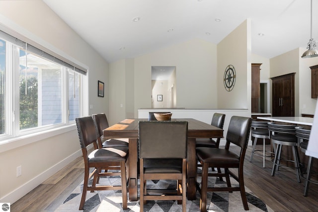 dining space with vaulted ceiling and dark wood-type flooring