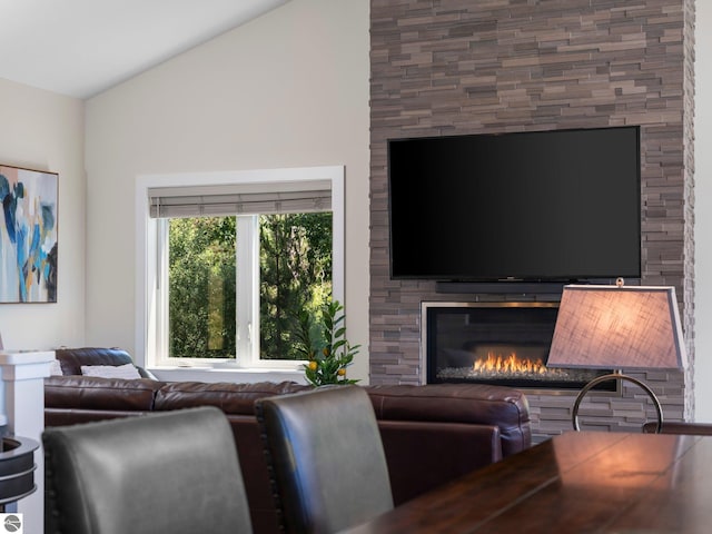 living room featuring a large fireplace and lofted ceiling