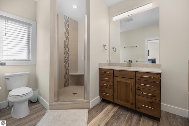 bathroom with toilet, an enclosed shower, wood-type flooring, and vanity