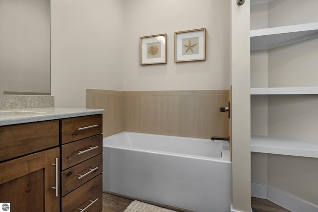 bathroom with vanity, a tub to relax in, and hardwood / wood-style flooring