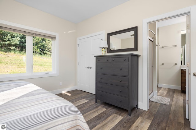 bedroom with ensuite bathroom and dark wood-type flooring