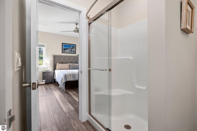 bathroom featuring wood-type flooring, an enclosed shower, and ceiling fan