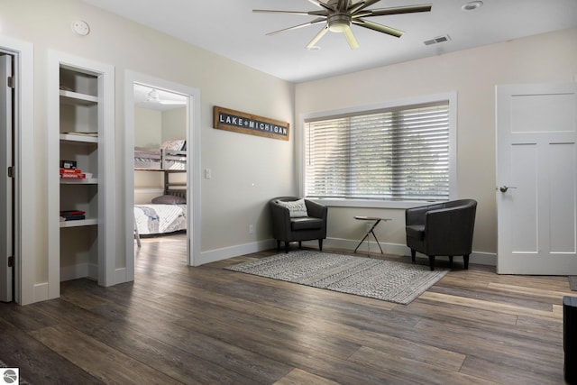 sitting room featuring built in features, ceiling fan, and dark hardwood / wood-style flooring