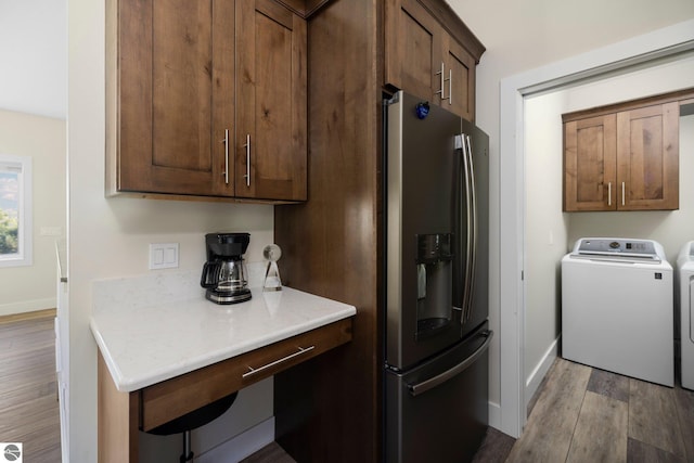 kitchen featuring washer and dryer, stainless steel fridge, and light wood-type flooring