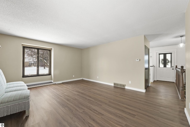 unfurnished living room featuring a textured ceiling, baseboard heating, and dark hardwood / wood-style flooring