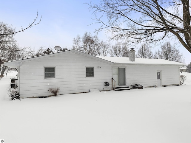 view of snow covered back of property