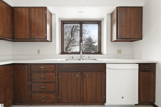 kitchen with dishwasher, dark brown cabinets, and sink