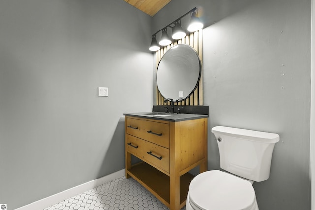 bathroom with toilet, vanity, and tile patterned flooring