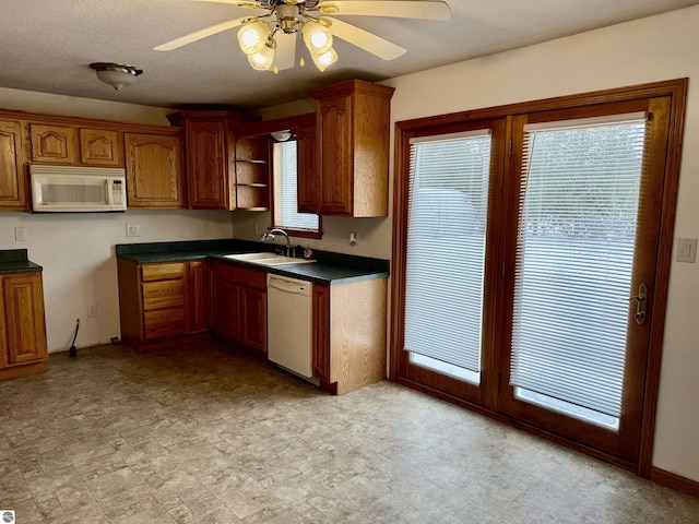 kitchen with white appliances, ceiling fan, and sink