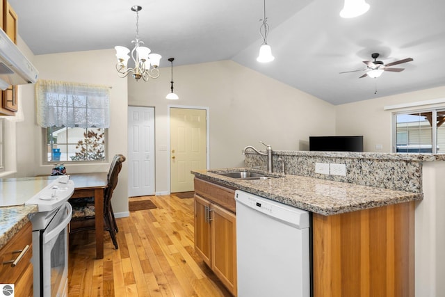 kitchen featuring sink, white appliances, lofted ceiling, and hanging light fixtures