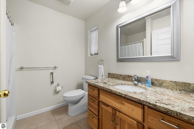 bathroom with tile patterned flooring, vanity, and toilet