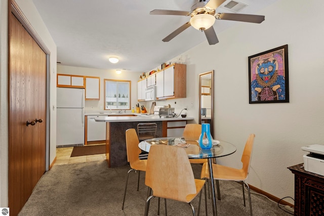 carpeted dining room featuring ceiling fan