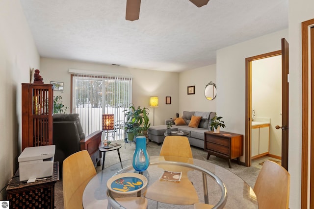 dining area with light colored carpet and a textured ceiling