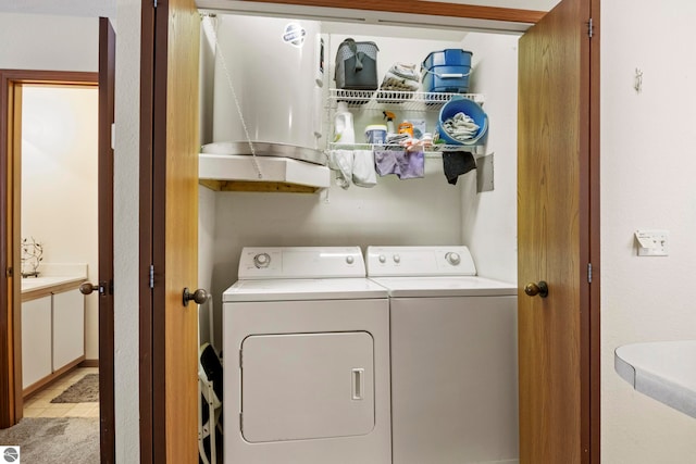 washroom with washing machine and clothes dryer and light tile patterned floors