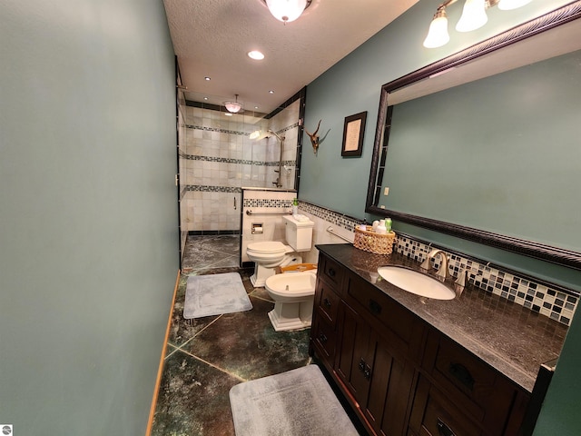 bathroom featuring vanity, a bidet, tasteful backsplash, toilet, and tiled shower