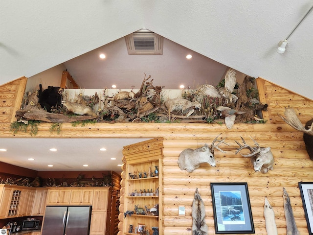 room details with stainless steel refrigerator, a textured ceiling, and log walls