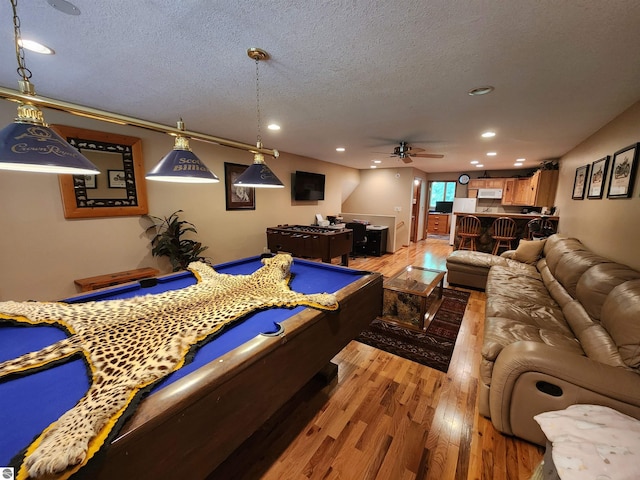 rec room with ceiling fan, hardwood / wood-style floors, a textured ceiling, and pool table