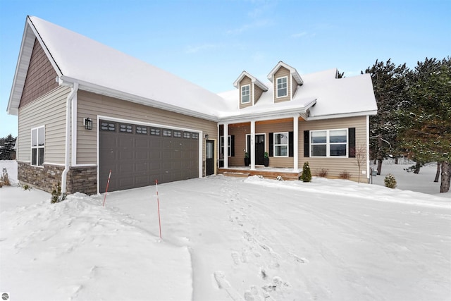 new england style home featuring covered porch and a garage