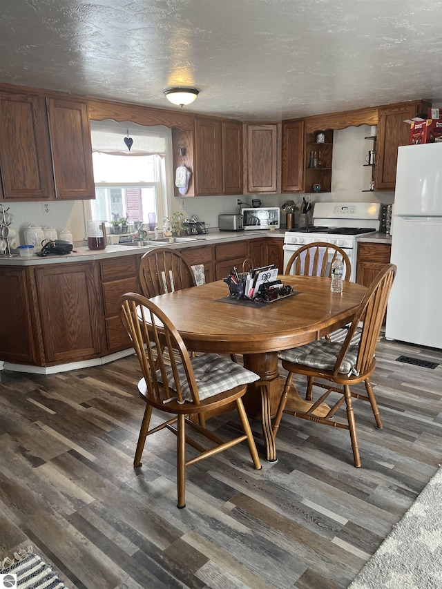 dining space with a textured ceiling and dark hardwood / wood-style floors