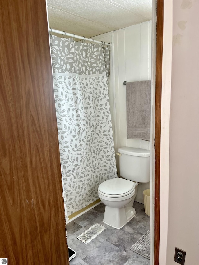 bathroom with toilet and a textured ceiling