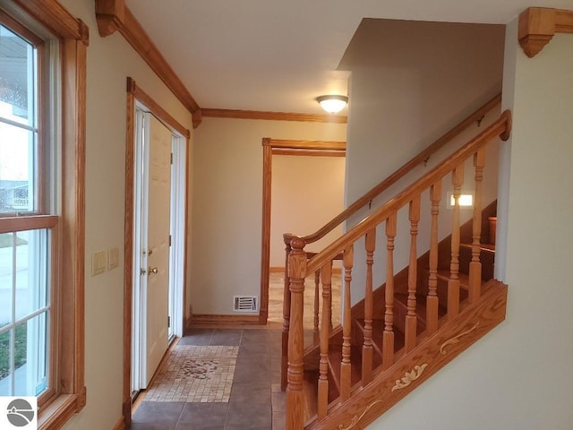 tiled foyer entrance featuring a wealth of natural light and ornamental molding