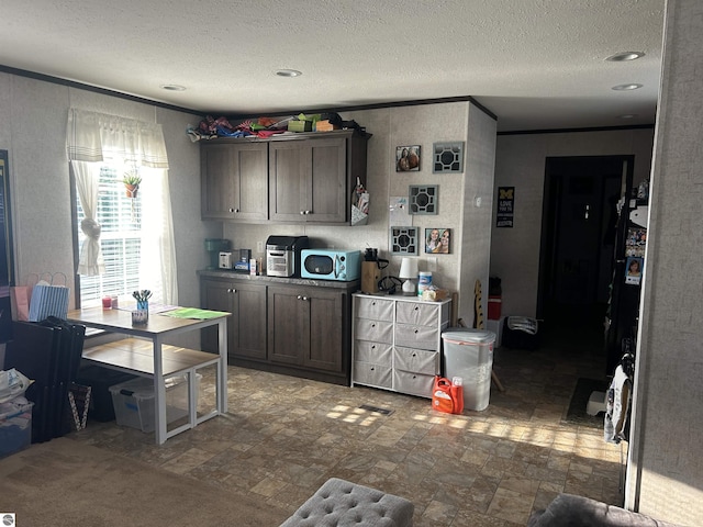 kitchen with a textured ceiling and dark brown cabinetry