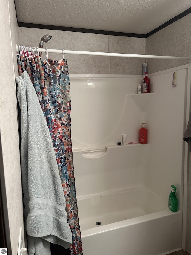 bathroom featuring a textured ceiling and shower / bath combination with curtain