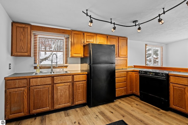 kitchen with sink, light hardwood / wood-style floors, rail lighting, and black appliances