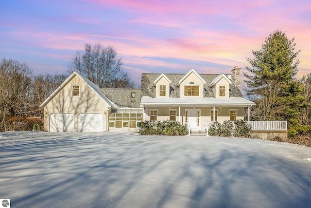 new england style home featuring covered porch and a garage