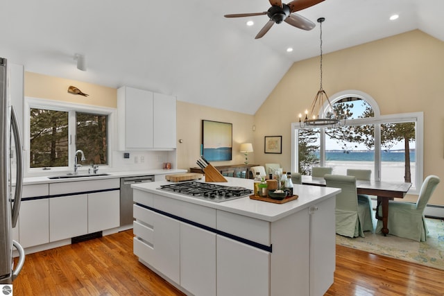 kitchen featuring stainless steel appliances, white cabinetry, light hardwood / wood-style floors, and sink