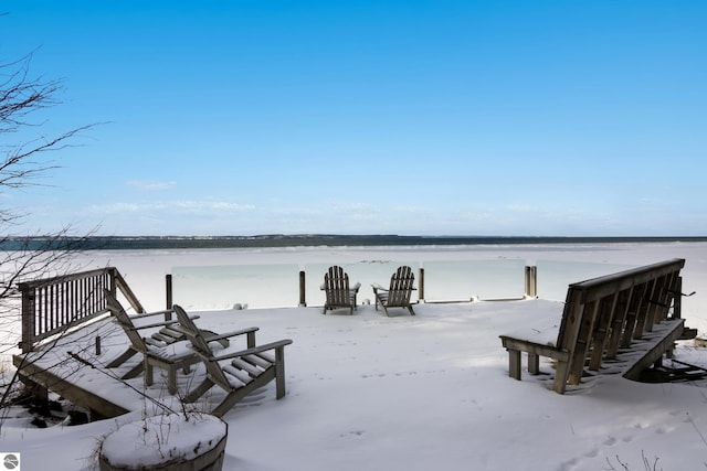 snow covered patio with a water view