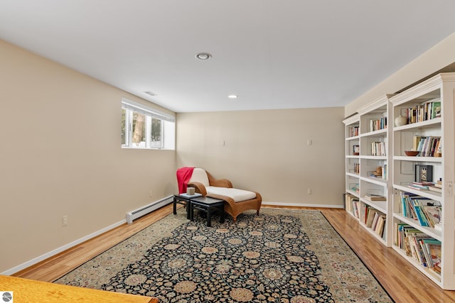 living area with a baseboard radiator and hardwood / wood-style flooring