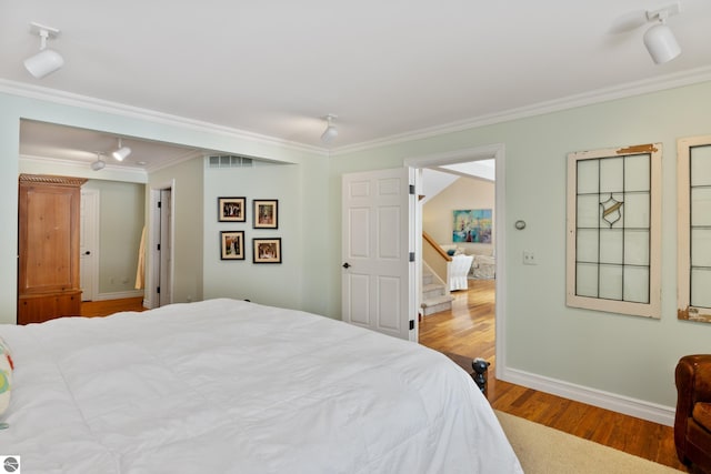 bedroom featuring ornamental molding and hardwood / wood-style flooring