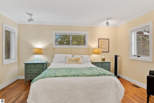 bedroom with ornamental molding and hardwood / wood-style flooring