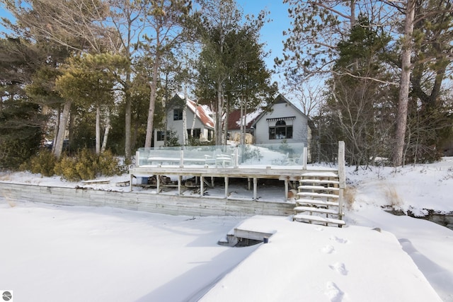 snow covered house featuring a wooden deck