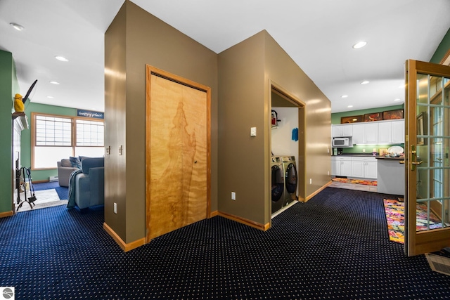 corridor with carpet flooring and washer and clothes dryer