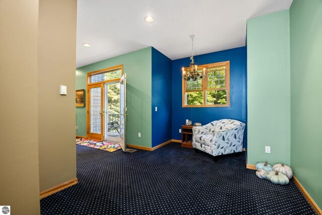 rec room featuring a notable chandelier and dark carpet