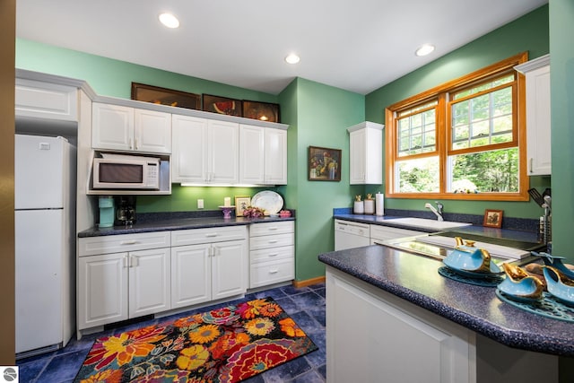 kitchen featuring white appliances, white cabinets, and sink