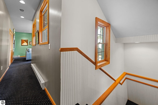 hallway with carpet flooring and a baseboard heating unit