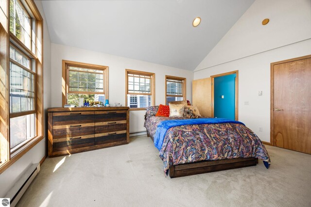 bedroom featuring lofted ceiling, a baseboard heating unit, and light colored carpet