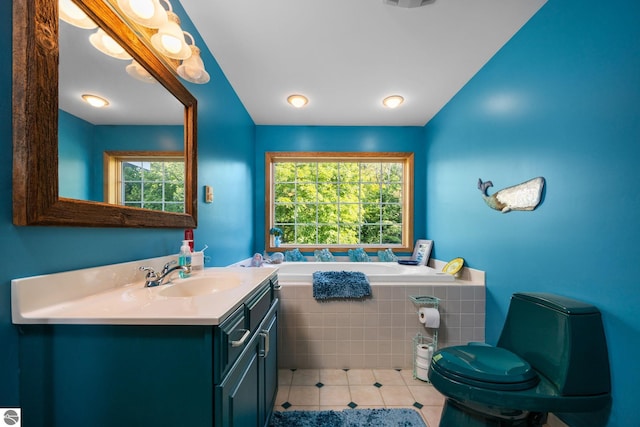 bathroom with vanity, tile patterned floors, and a relaxing tiled tub